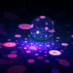 A glowing sphere reflects vibrant, circular patterns in purple and pink tones on a dark background.